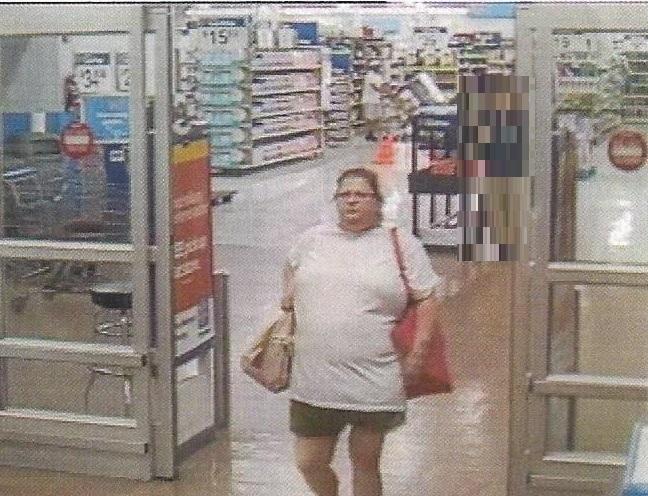 Shoplifting Suspect - woman wearing a tan tshirt and green shorts, carrying two bags