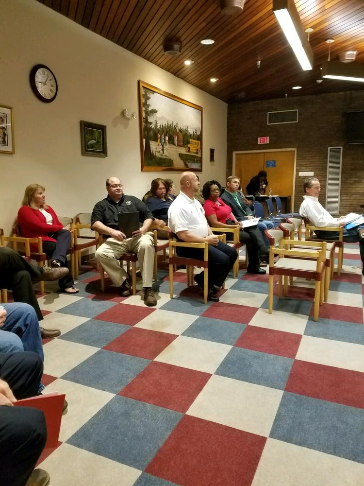 Group of people sitting in chairs with notebooks