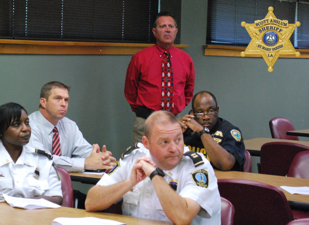 Several officers sitting and one standing and listening