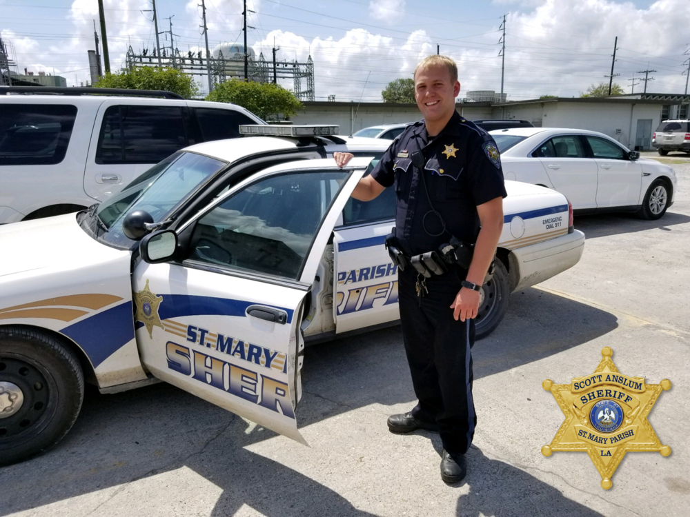 Sgt Eriq Blanchard holding the open door of patrol vehicle