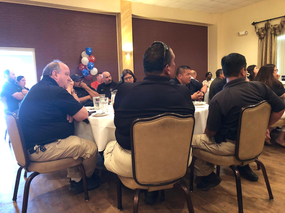 Officers seated at a table, listening to the presentation