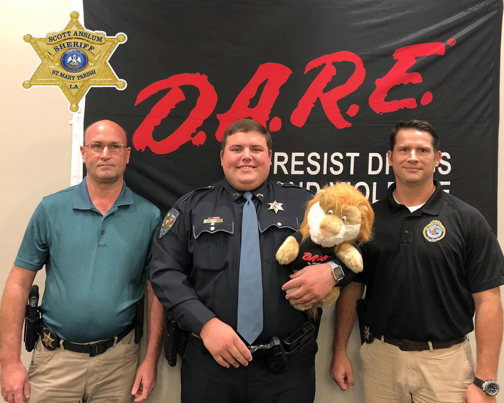 Officers in front of a DARE poster