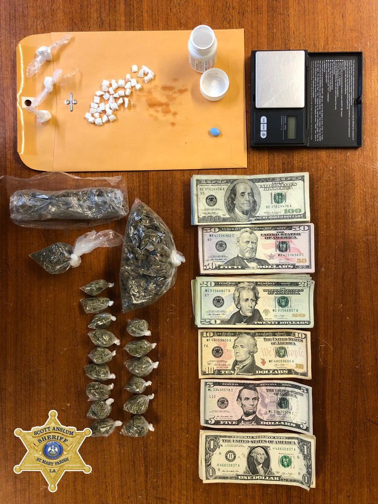 An overhead shot of money, drugs and a scale lined up on a table as their recovery efforts.