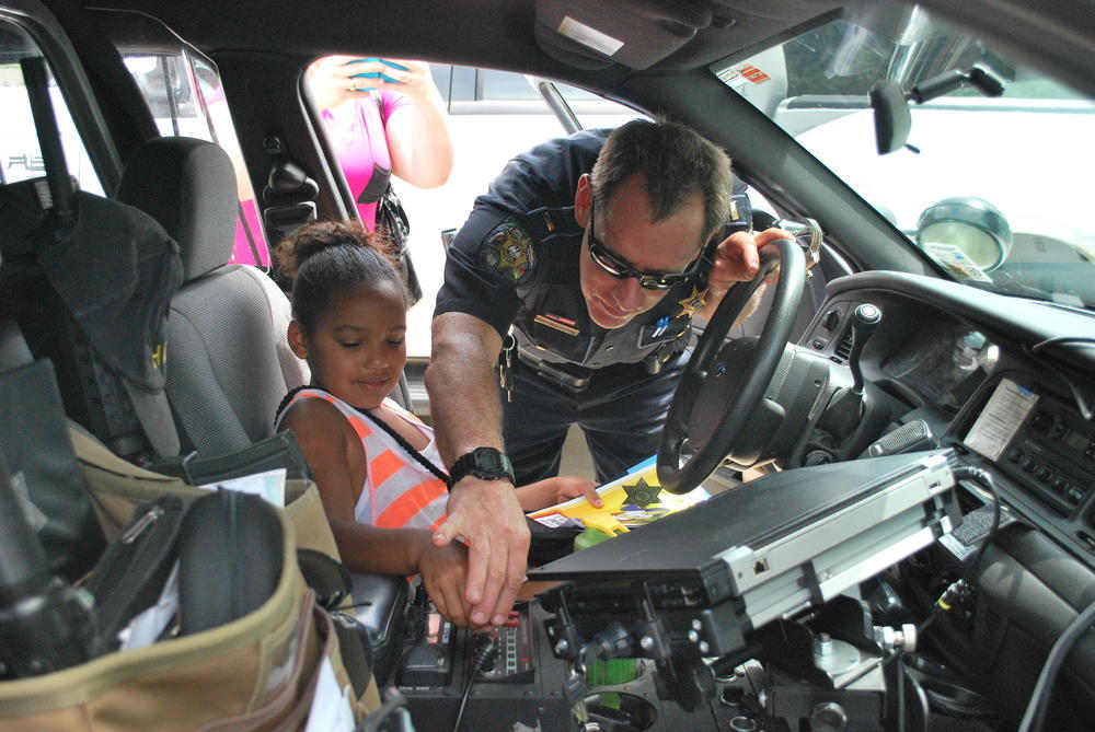 Lt. Dan Wiedenboerner showing off his police cruiser to kids