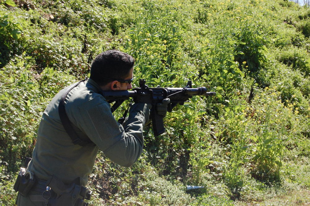 Officer taking aim with a rifle at the shooting range