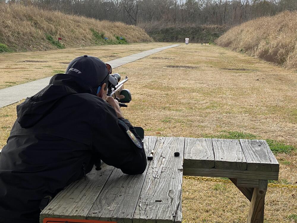 Officer aiming down range with rifle