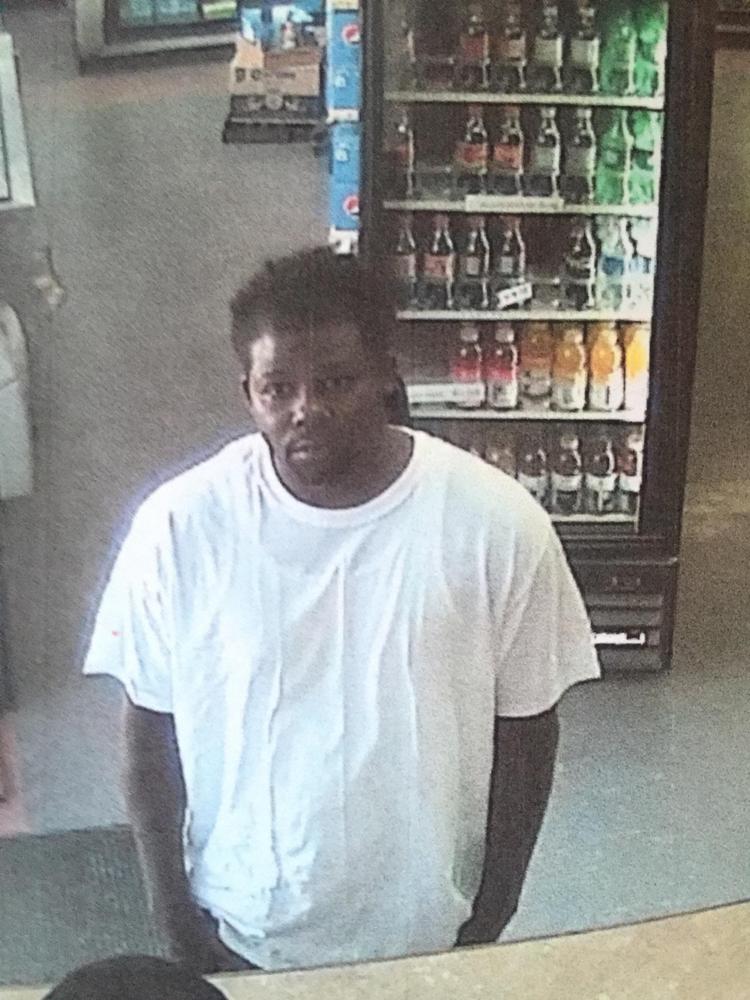 black male in white tshirt standing at counter