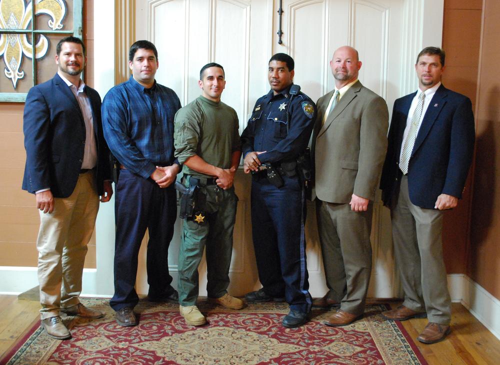 6 men standing in a line wearing uniforms and suits